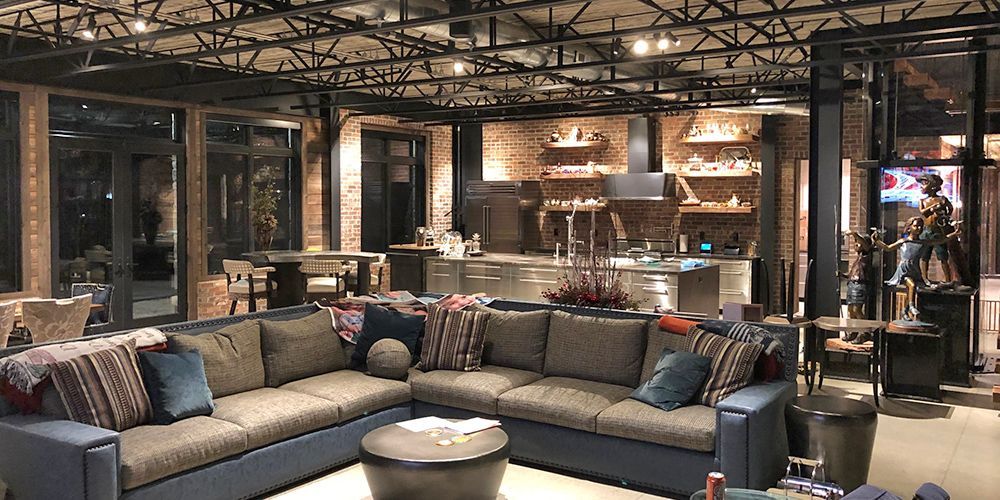 Modern lounge with gray sectional sofa, warm lighting, and shelves in a stylish interior showroom