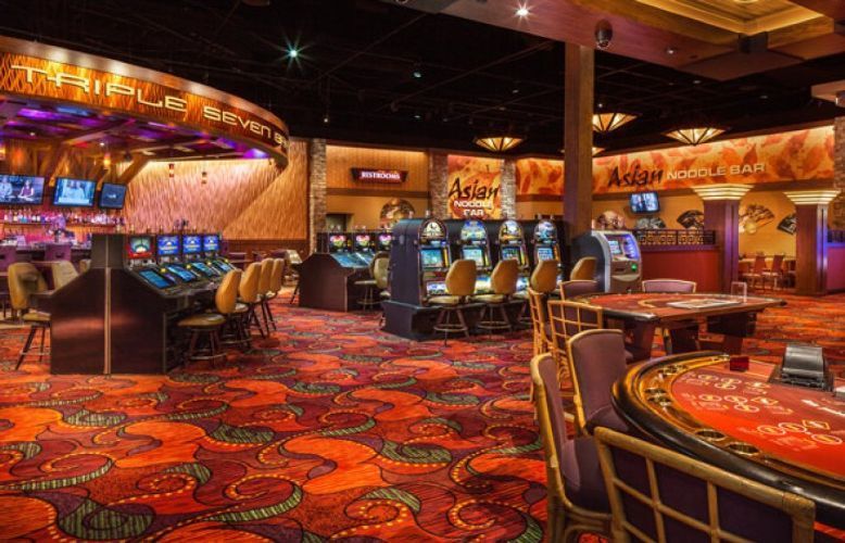 Casino gaming floor with slot machines, glowing lights, and red patterned carpet