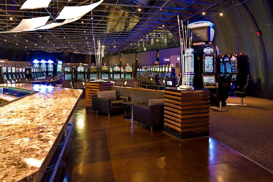 Modern restaurant interior with warm lighting, wooden tables, and a long illuminated bar counter