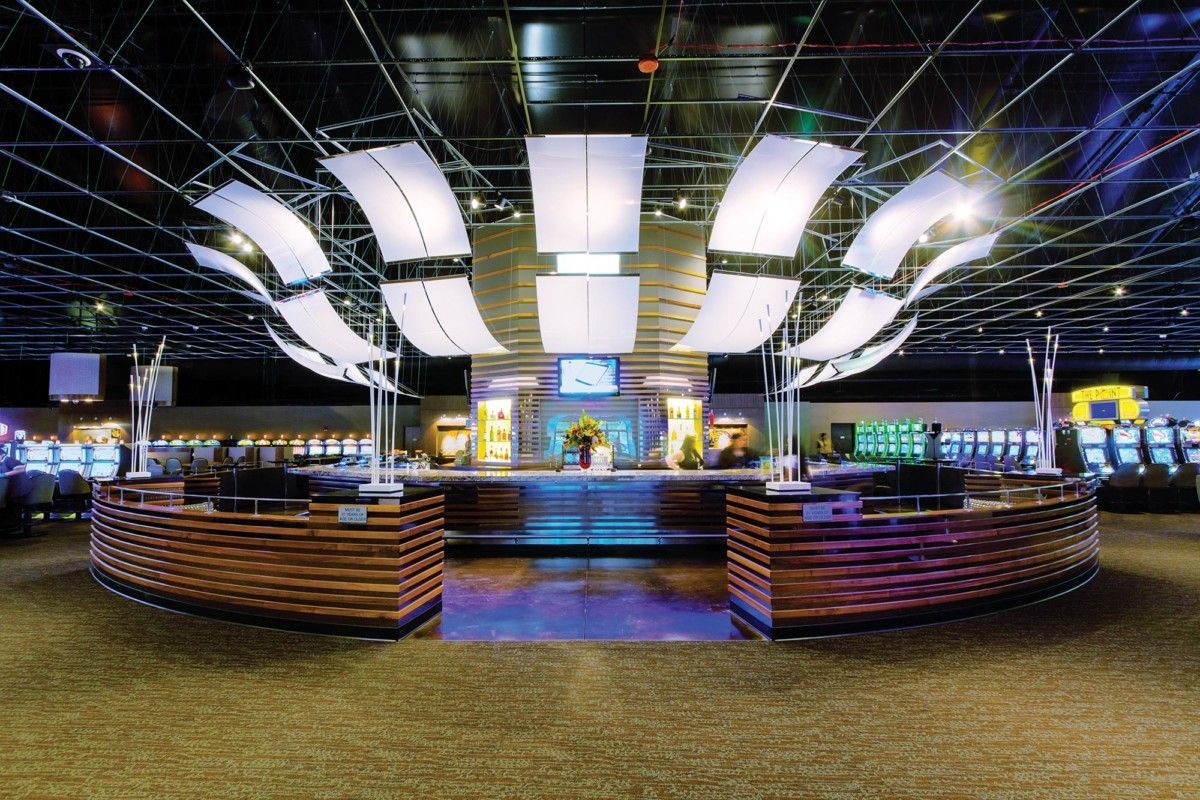 Modern illuminated nightclub interior with curved bar, glossy floor, and hanging white light panels
