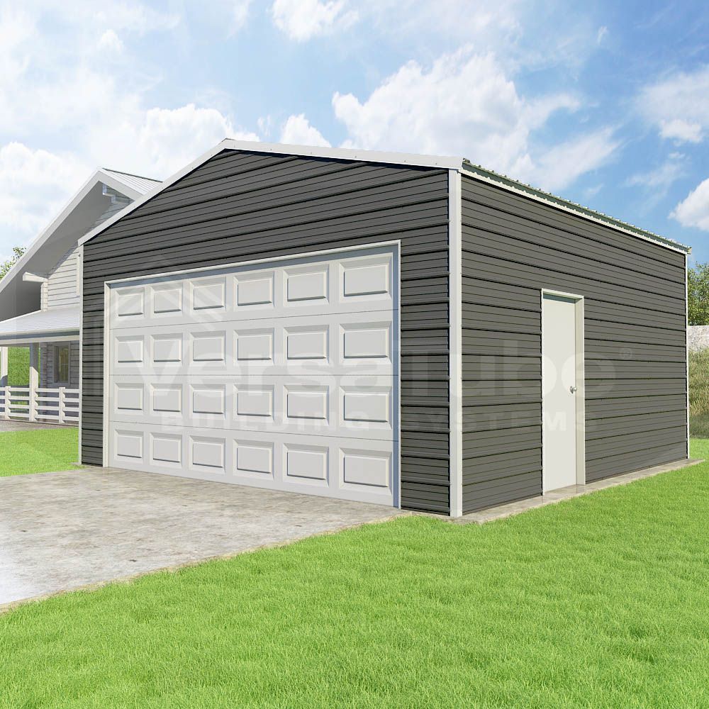 Gray detached garage with white door and driveway on a green lawn under a blue sky