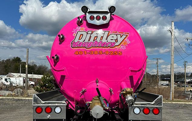 A pink dirtley truck is parked in a parking lot