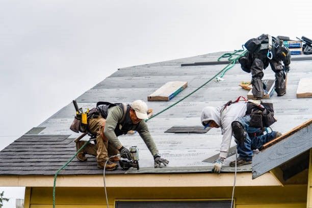 a group of men are working on a roof .