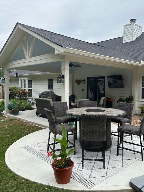 A patio with a table and chairs in front of a house