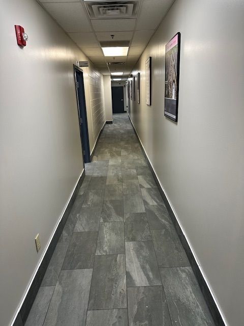 A long hallway with tile floors and white walls