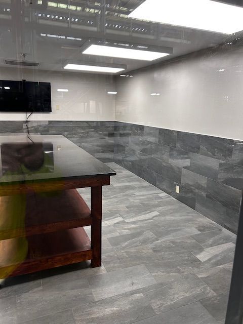 A room with a table and a computer on the wall