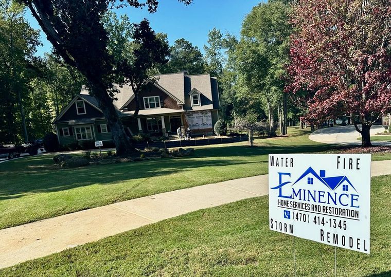 Outdoor with house, trees and the eminence Home Service and Restoration signage