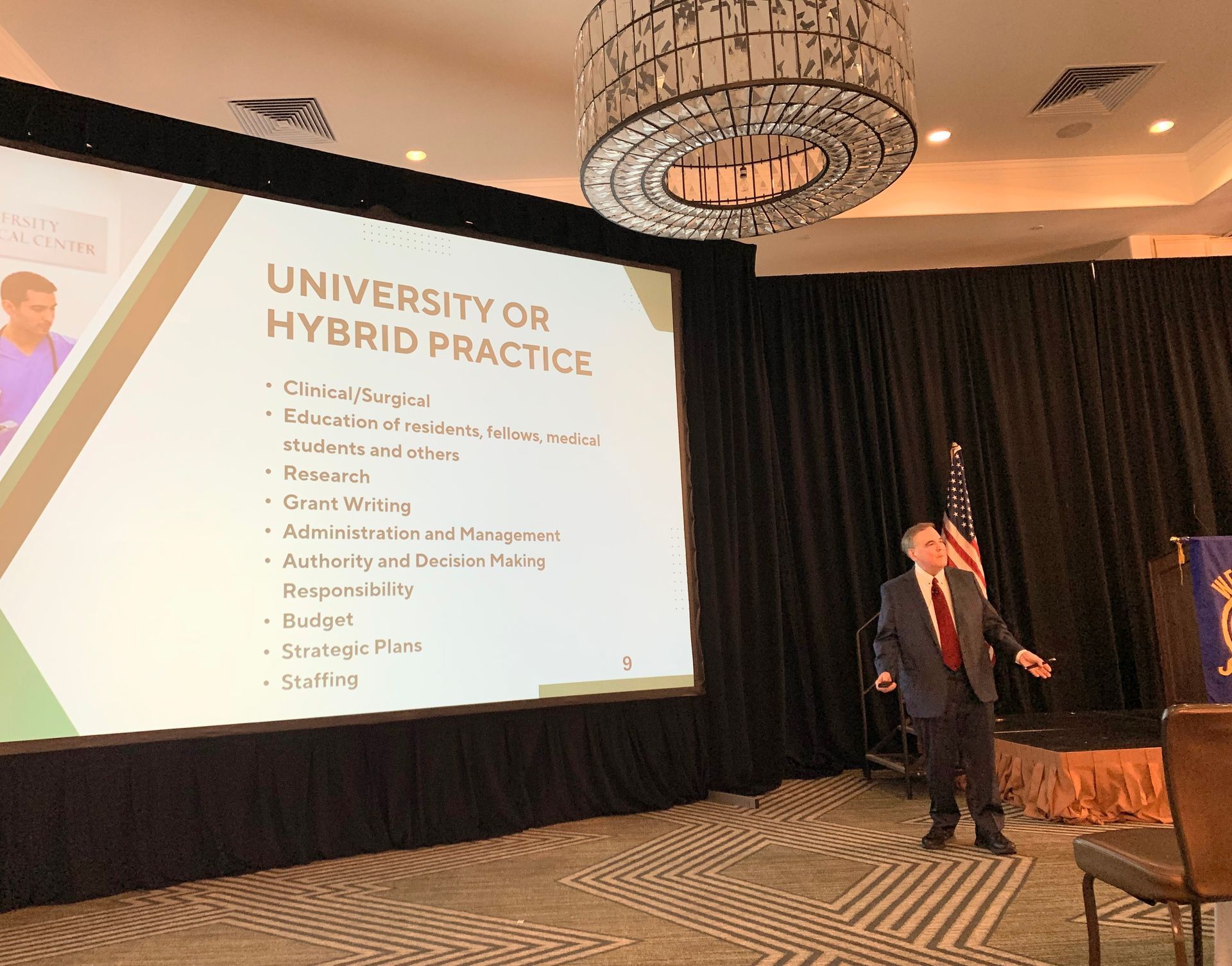 Man in suit presents at a conference; text on screen: 