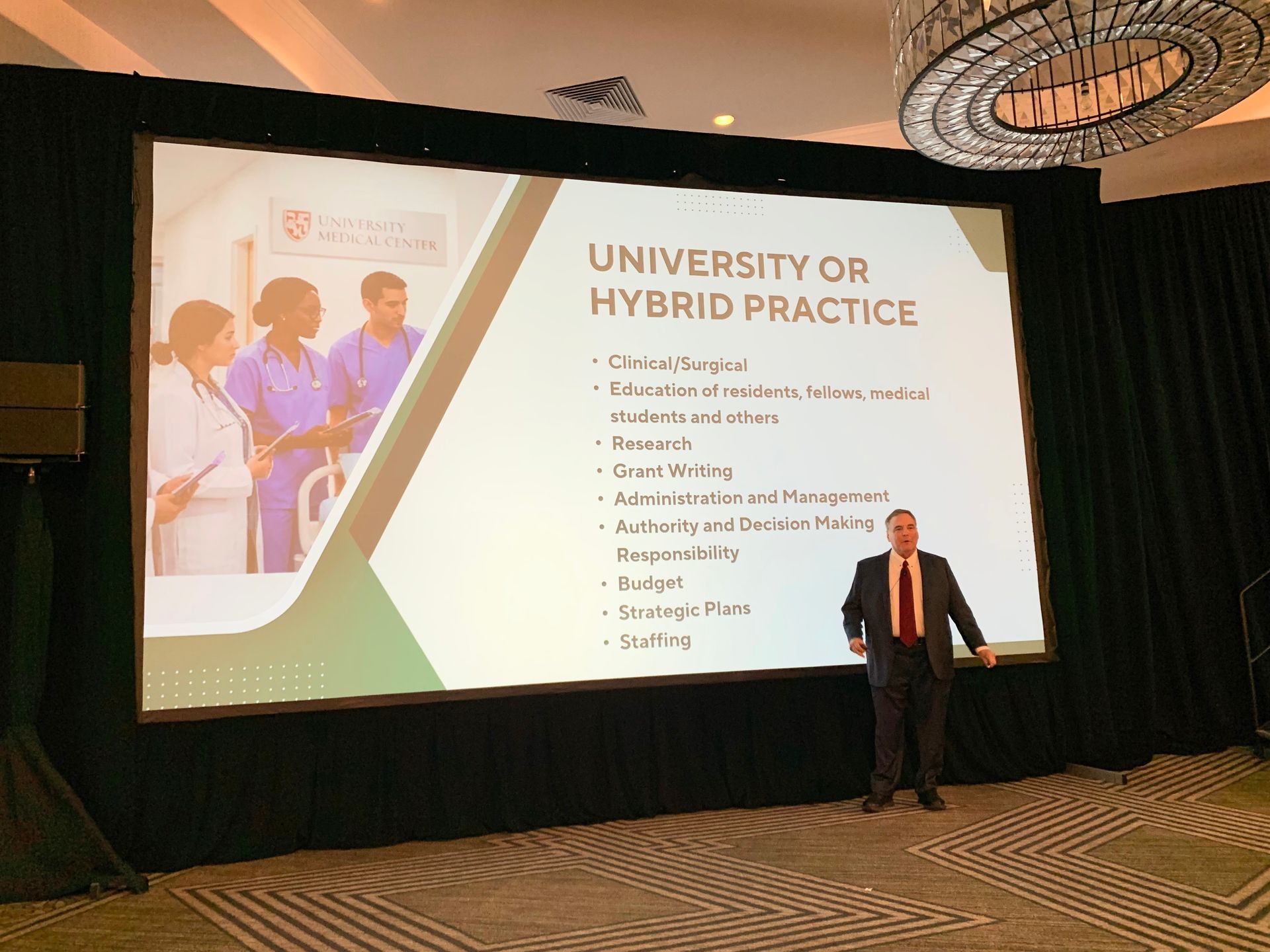 Man in suit presents to a screen titled 