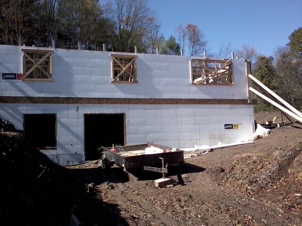 A trailer is parked in front of a house under construction