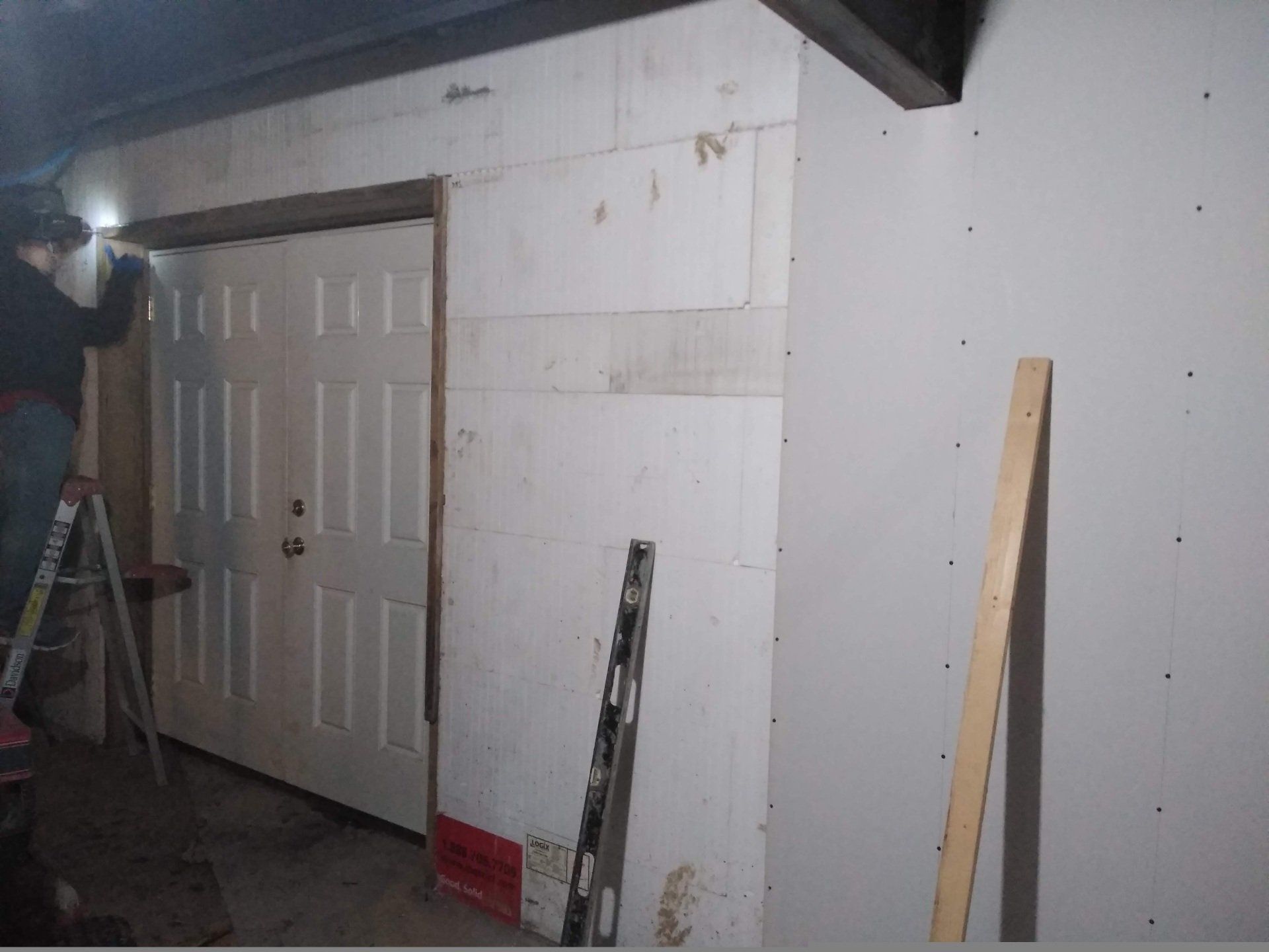 A concrete wall in a basement with a staircase leading up to it