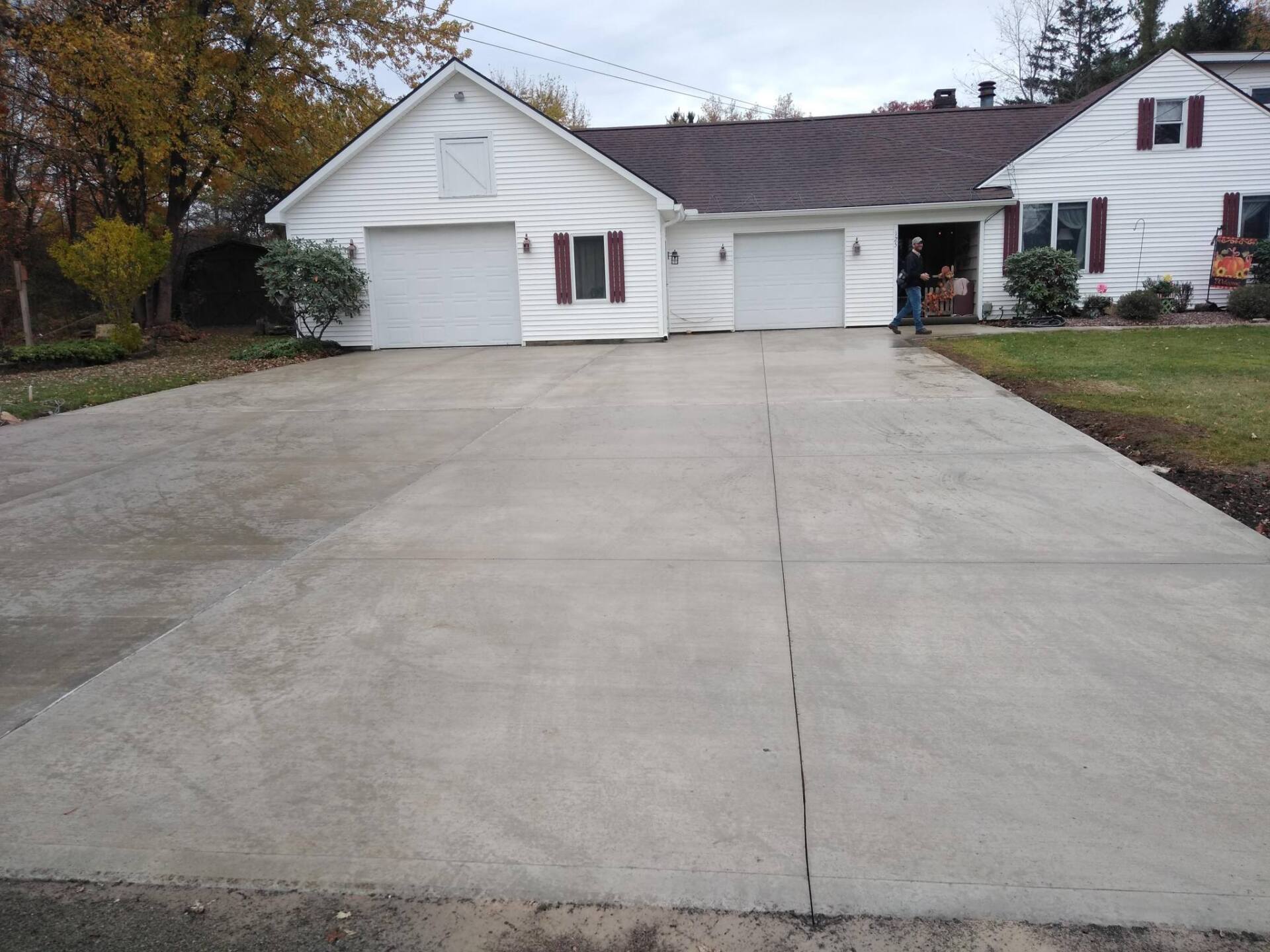 A white house with a concrete driveway in front of it