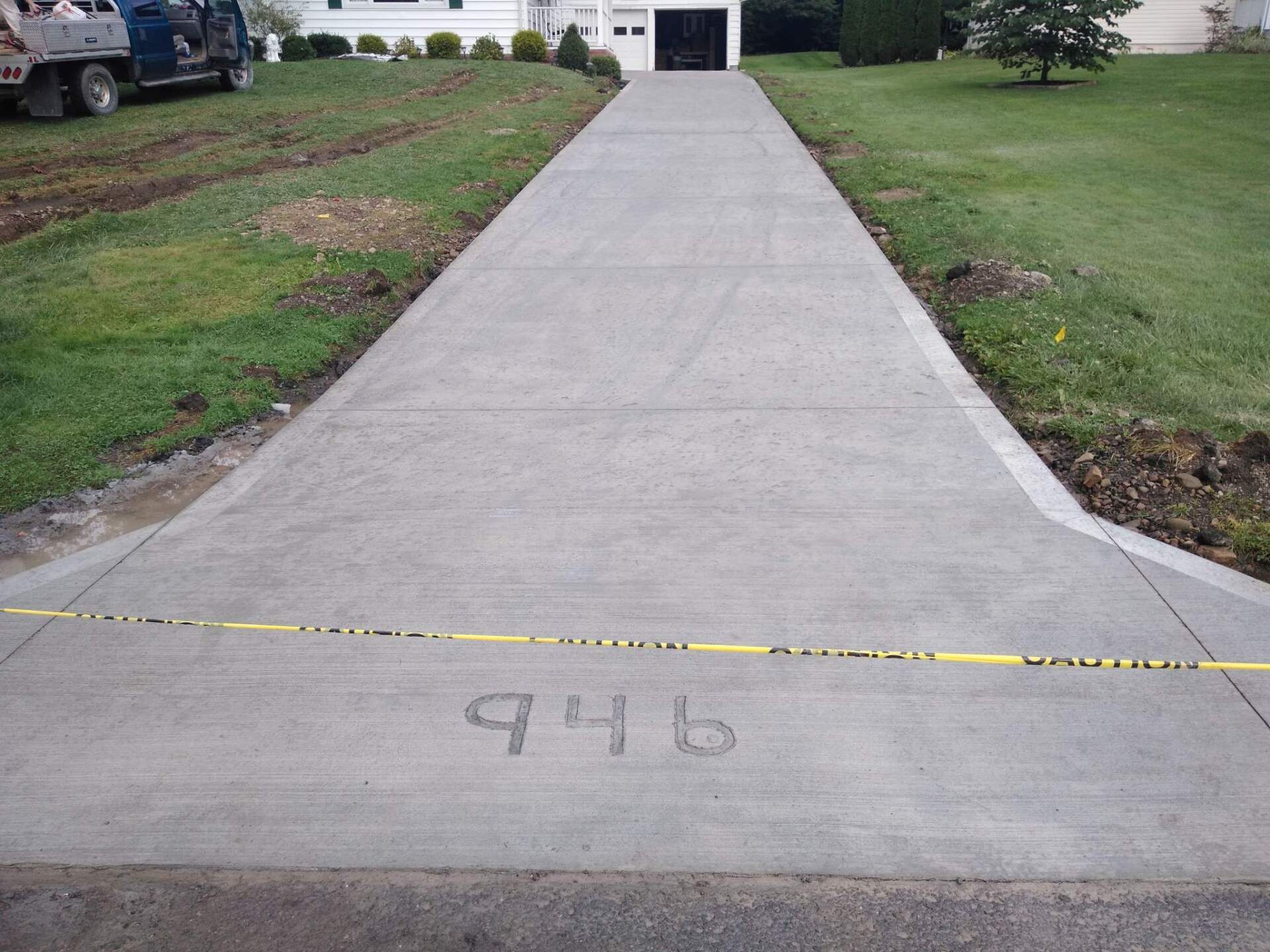 A concrete driveway with the number 946 written on it