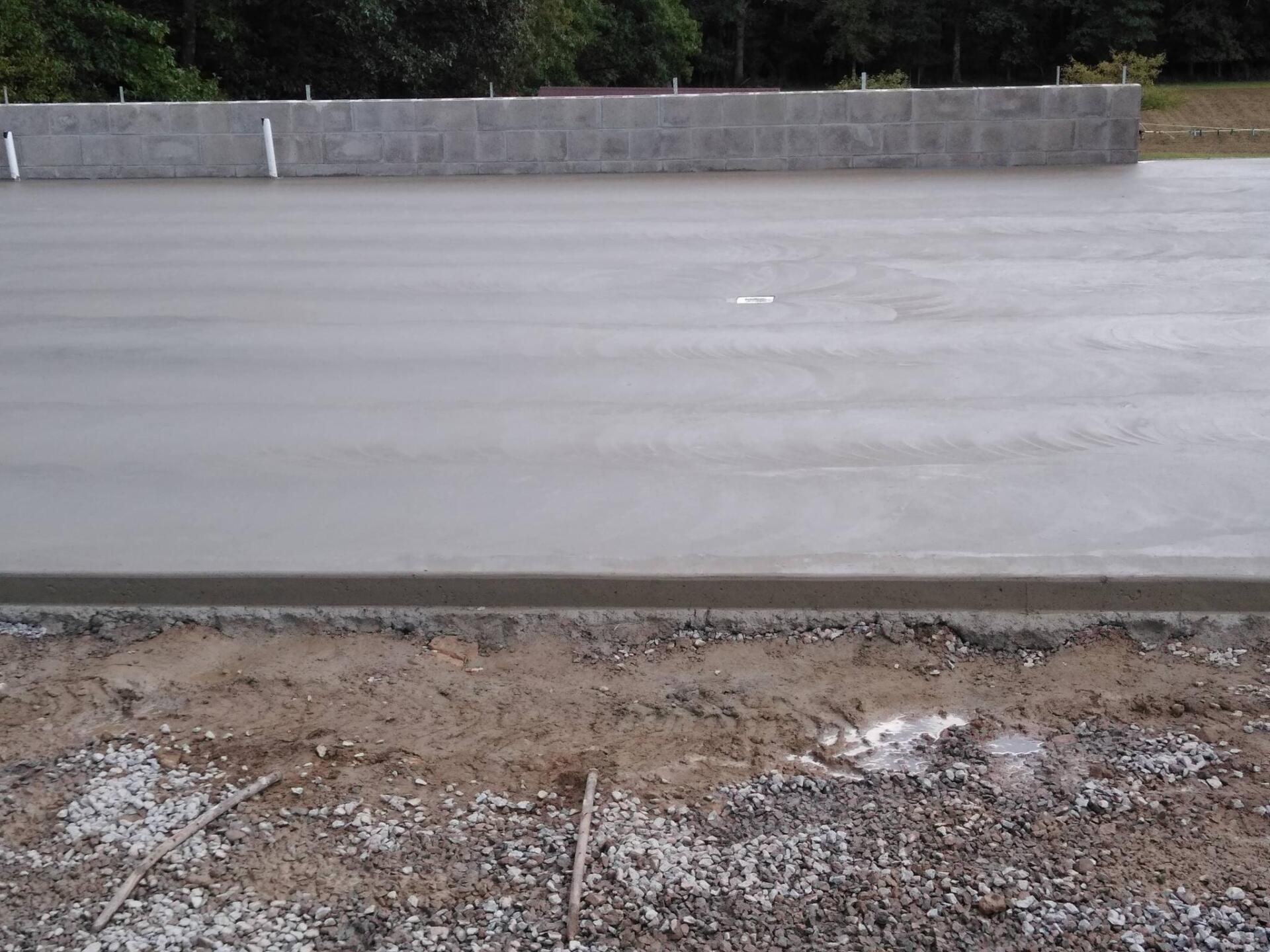 A concrete surface with a brick wall in the background