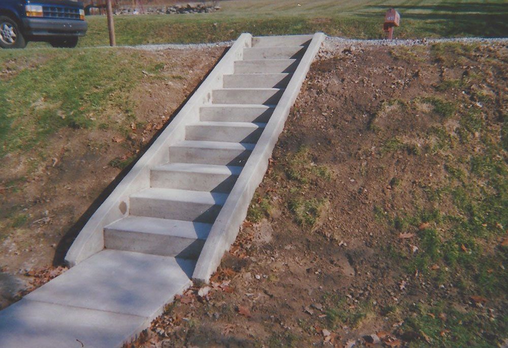 A set of concrete stairs going up a grassy hill