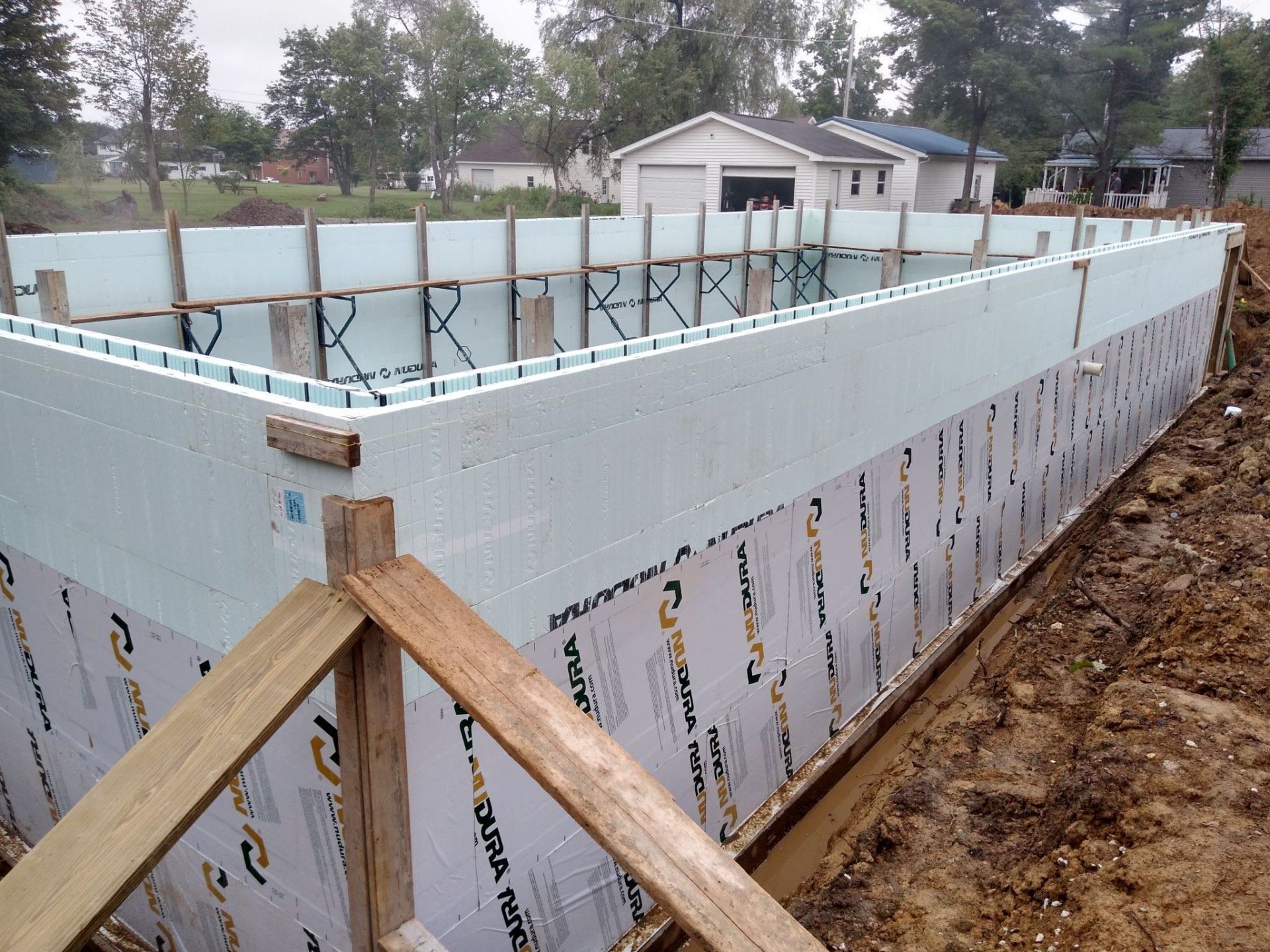 A large swimming pool is being built in the dirt