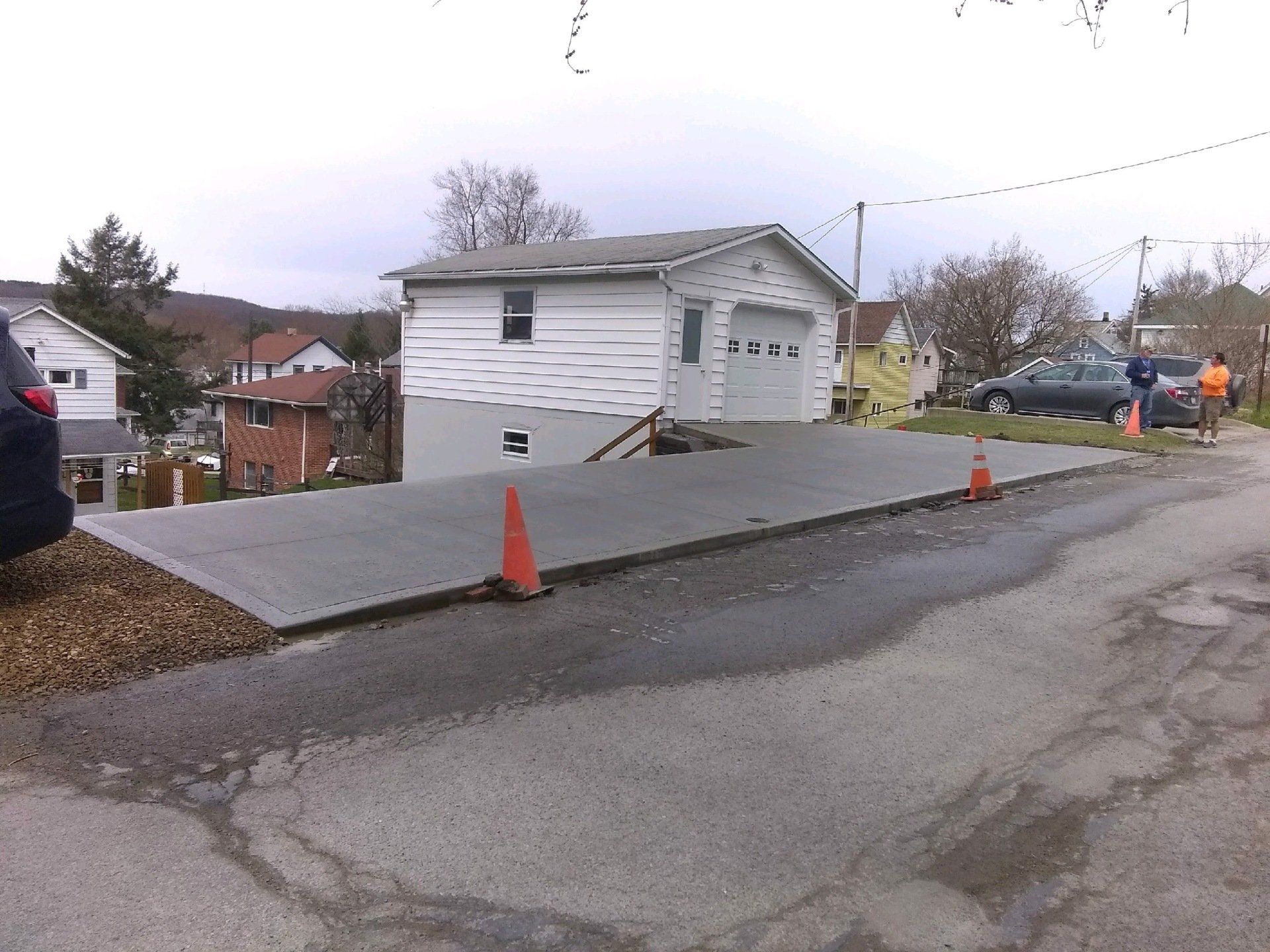 A concrete driveway is being built in front of a house