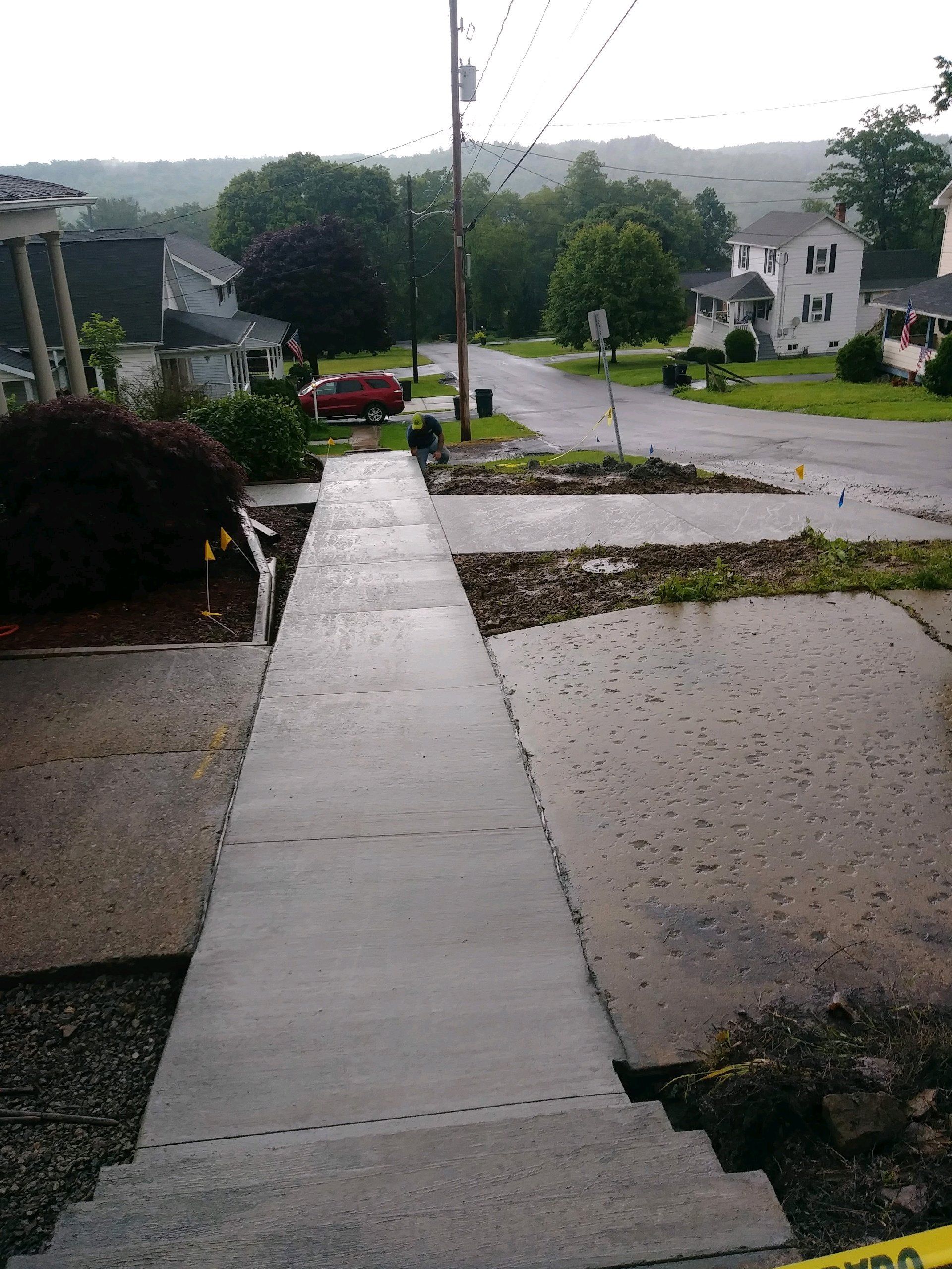 A concrete driveway is being built in front of a house