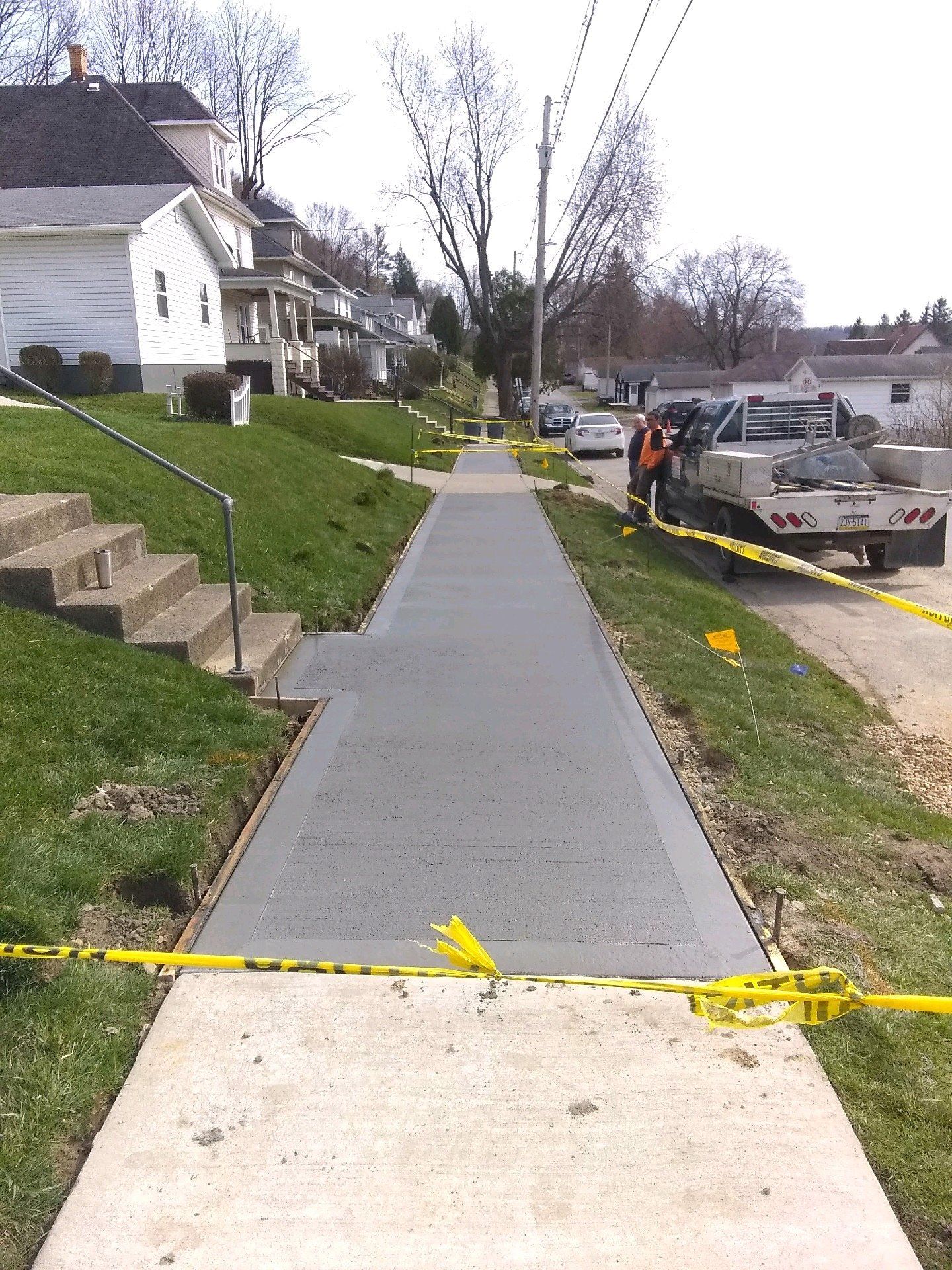 A sidewalk with a truck parked on the side of it
