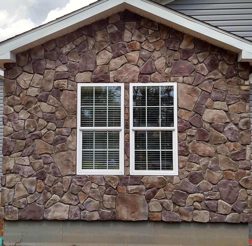 A house with a stone wall and two windows