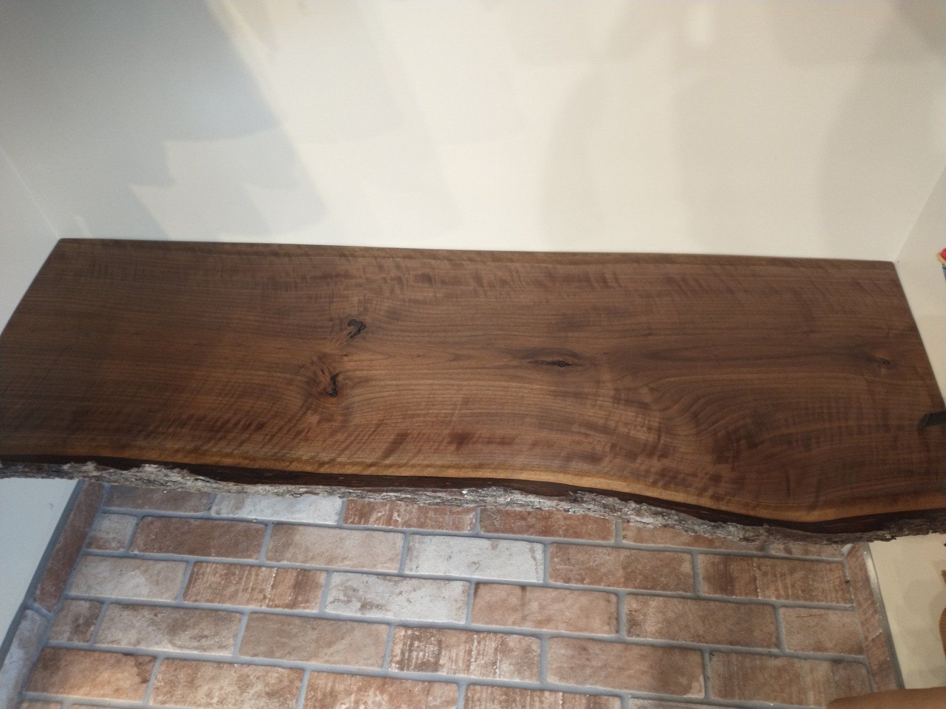 A wooden table with a brick wall in the background