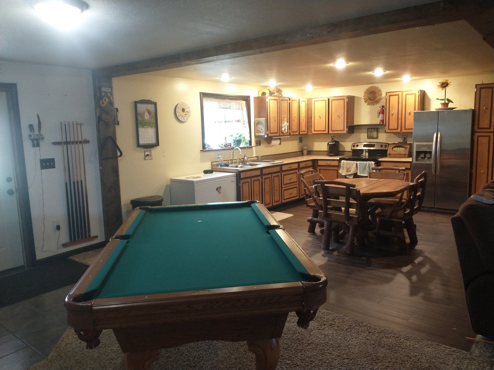 A pool table in a kitchen with a table and chairs