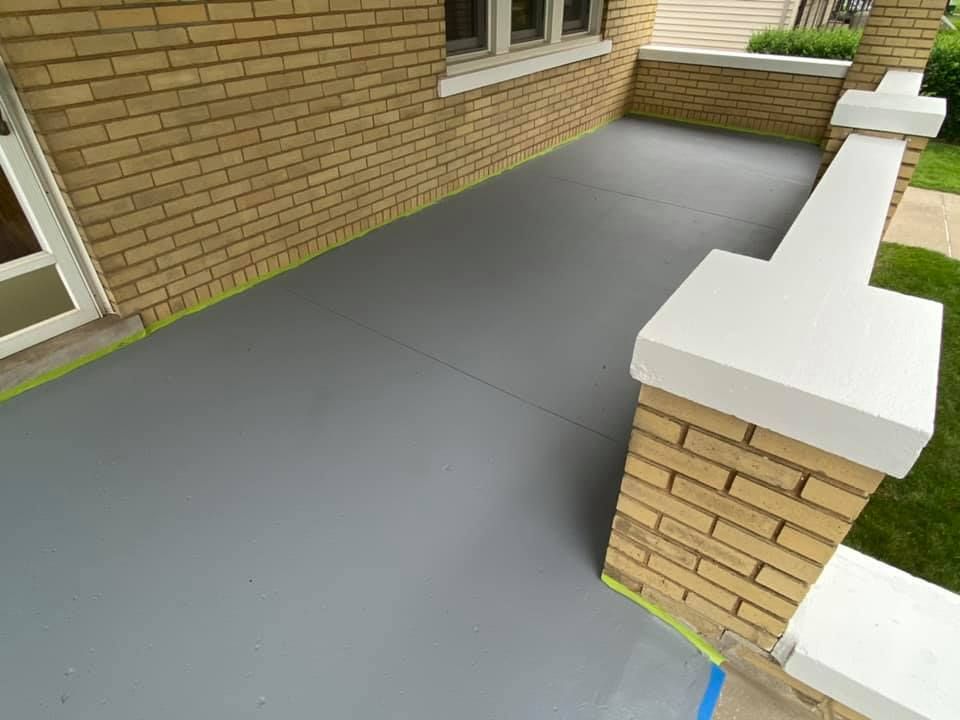 Painted cement deck with brick walls and white railings in West Des Moines, Iowa.