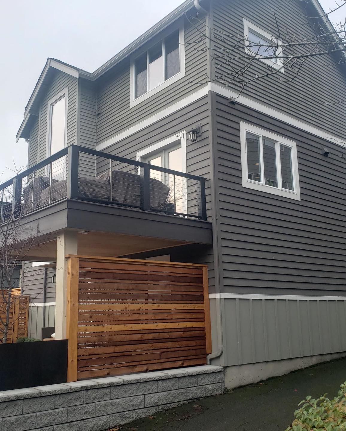 Exterior house painted gray with stained deck in Johnston, Iowa. 