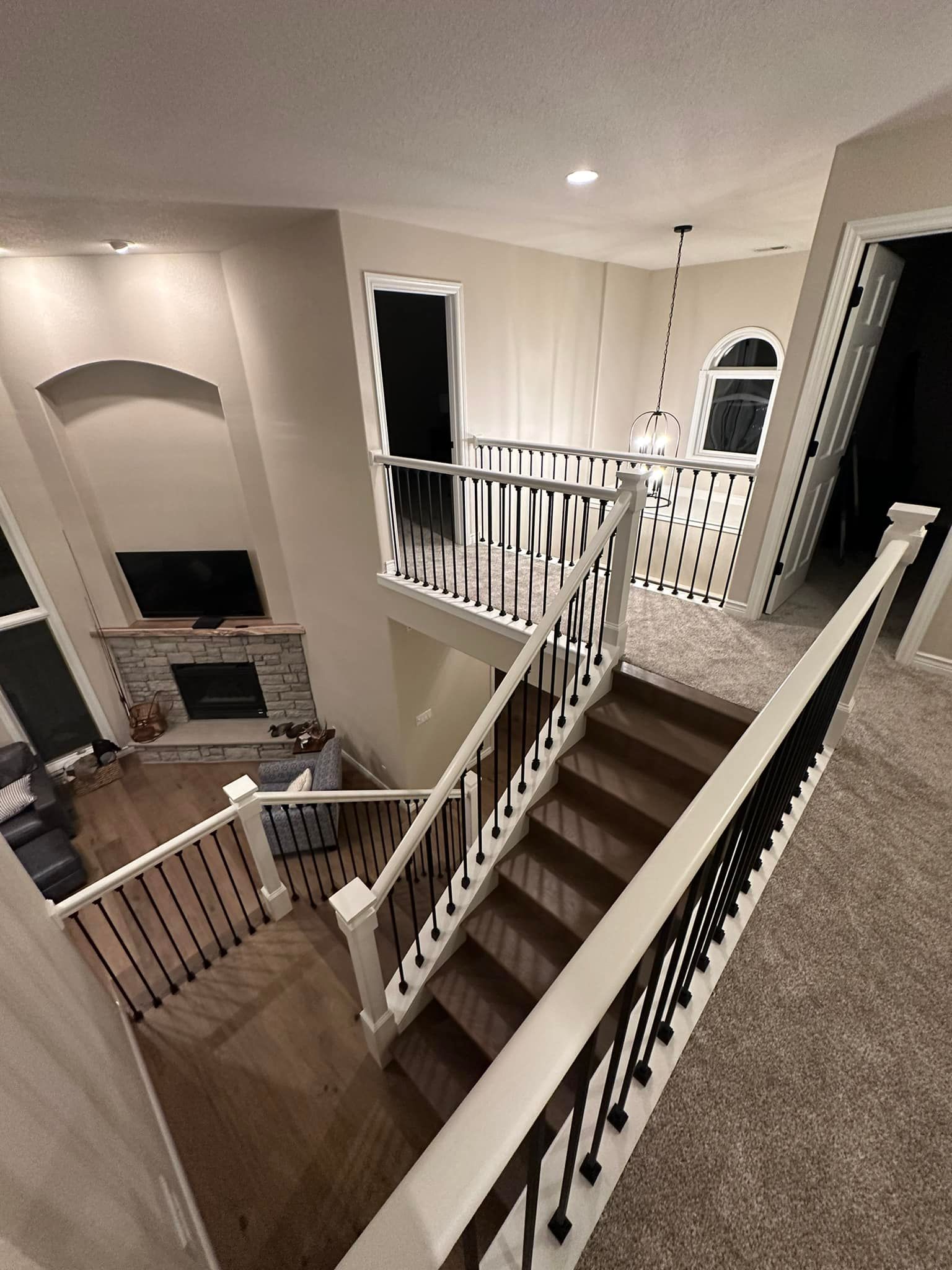 Room with green walls, dark wood floors, and a rug. It has a piano, french doors, and a window.