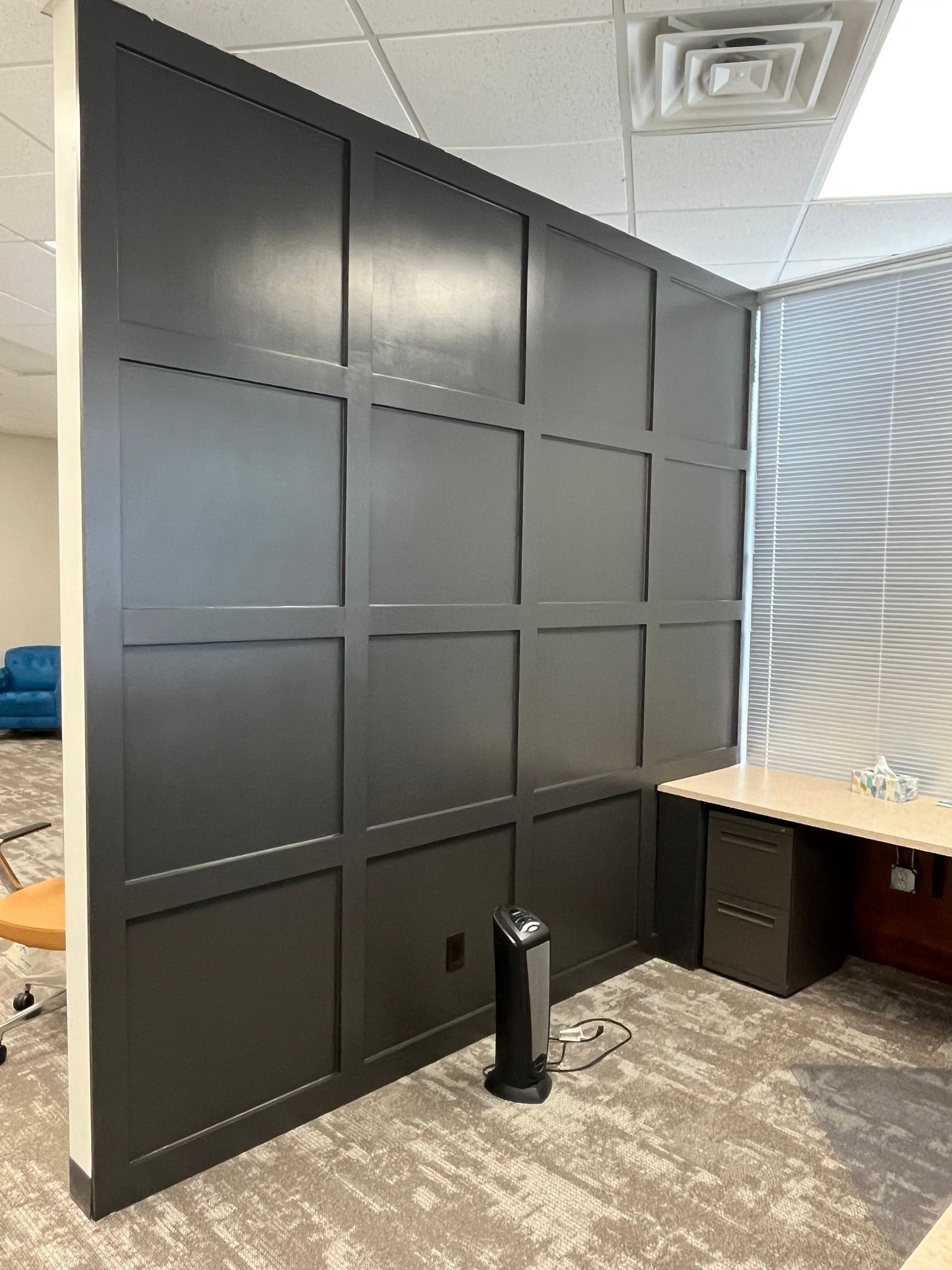 Office space painted white with desk and black accent wall in West Des Moines, Iowa.