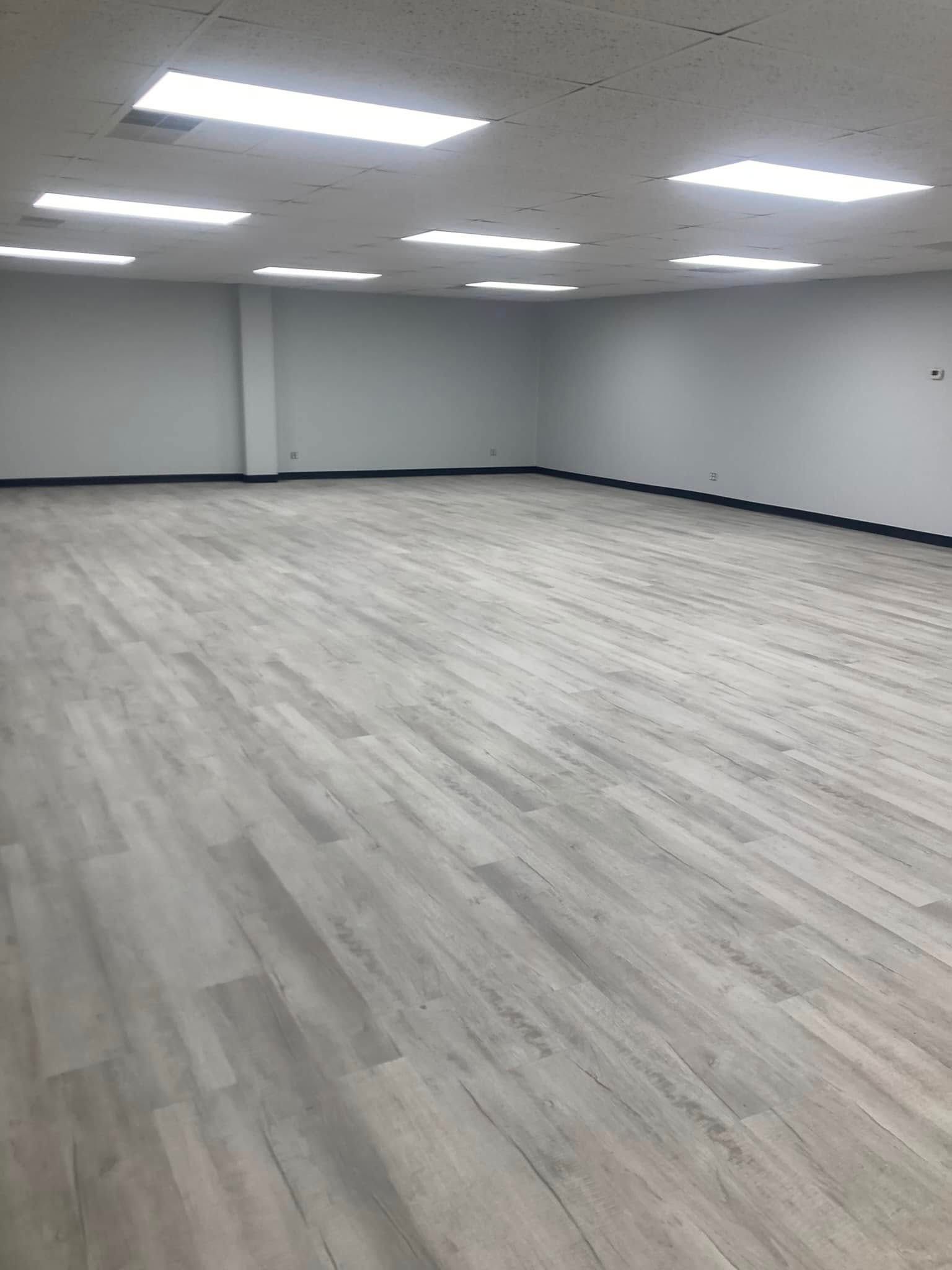 Painted commercial Room with white walls and wood floor in Ankeny, Iowa.