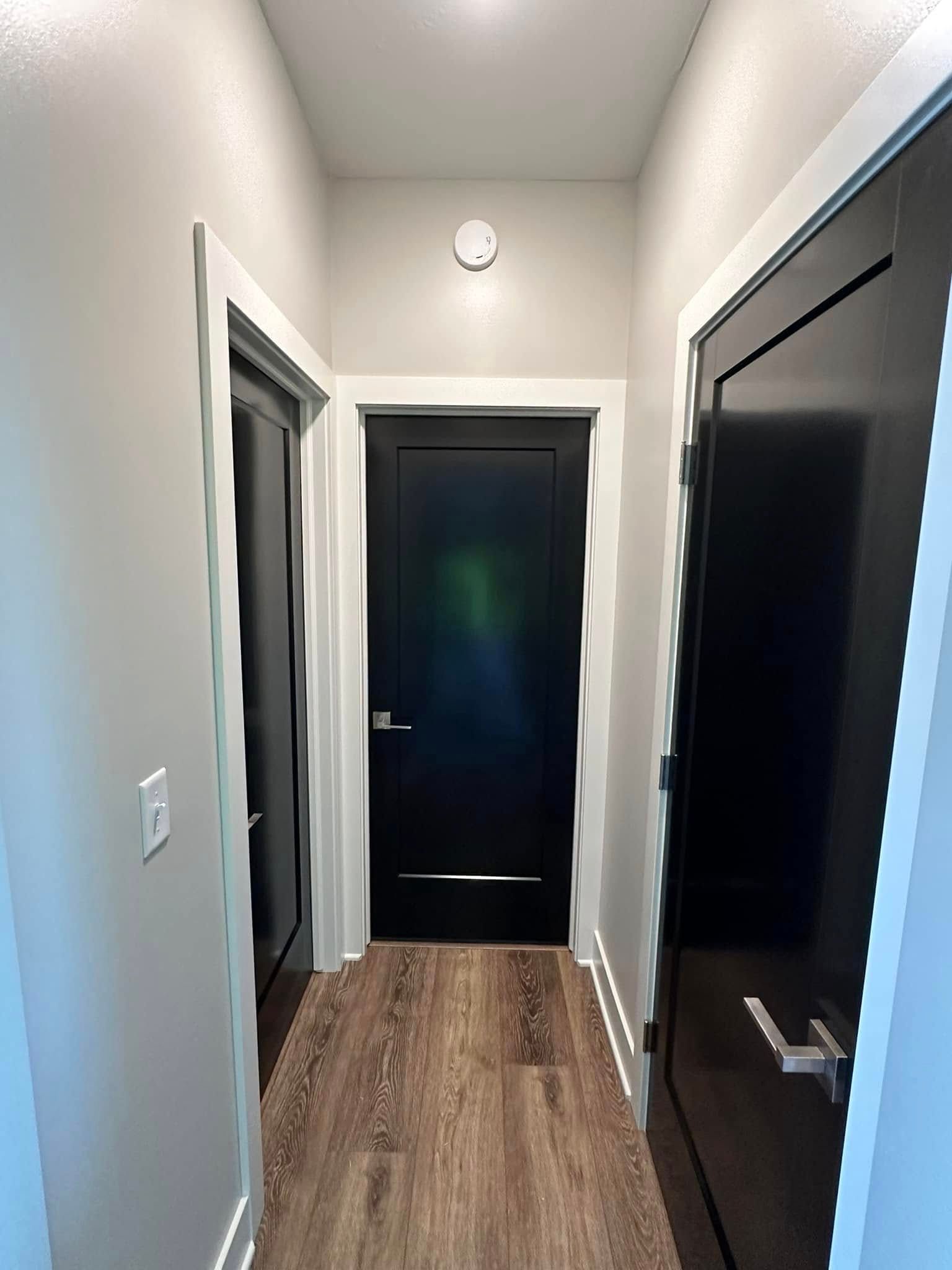 painted white walls and black doors in hallway in Ankeny, Iowa.