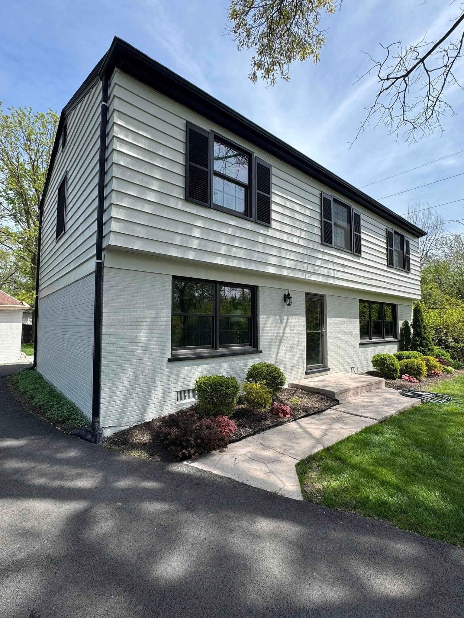 White painted brick house exterior completed by Harmony Painting in Urbandale, Iowa.