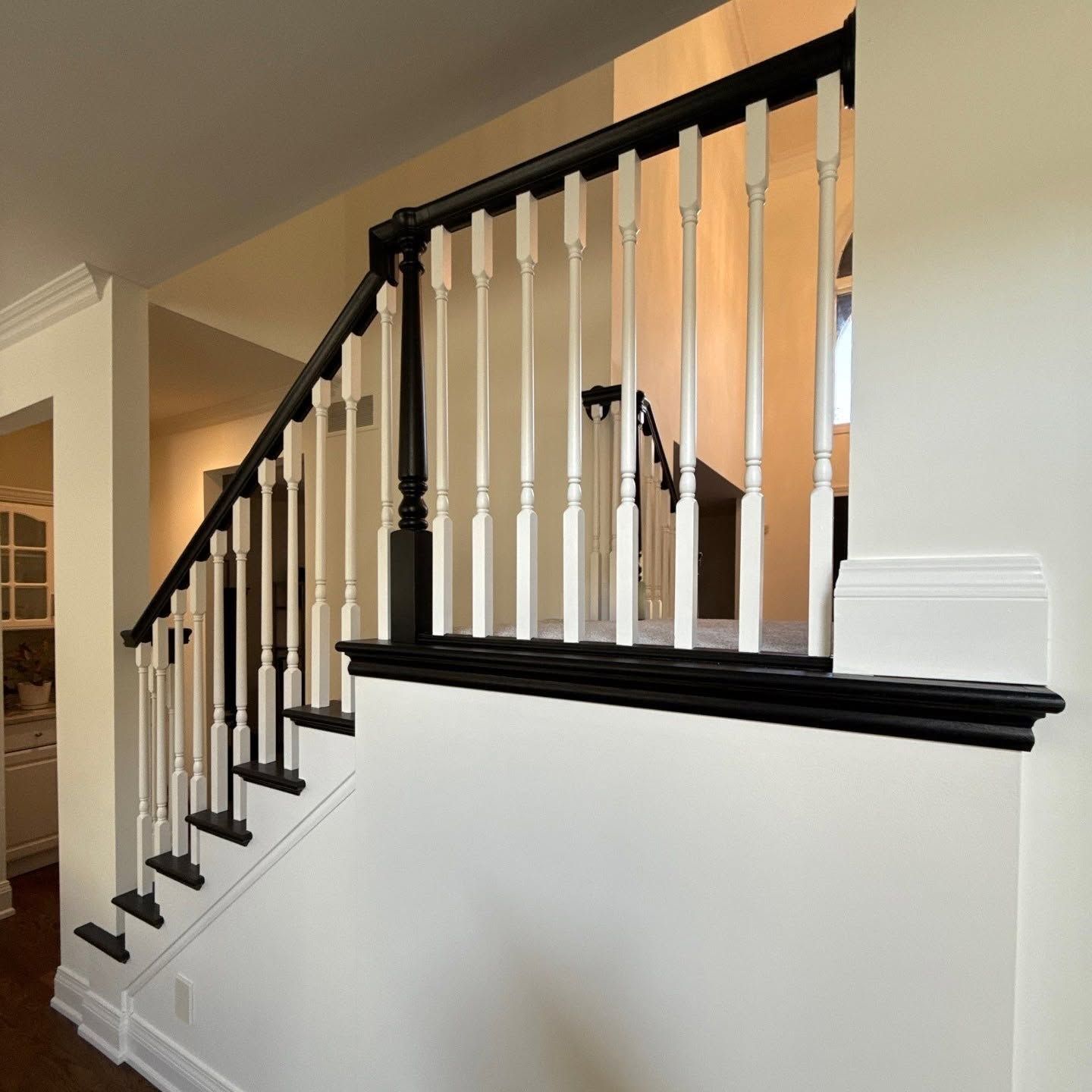 Painted stairwell landing black with white spindles in Ankeny, Iowa. 
