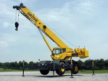 Yellow Grove mobile crane with an extended boom on a construction site.