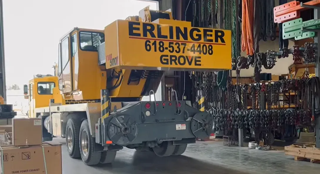 Yellow Erlinger Grove crane inside a warehouse; phone number 618-537-4408 visible.