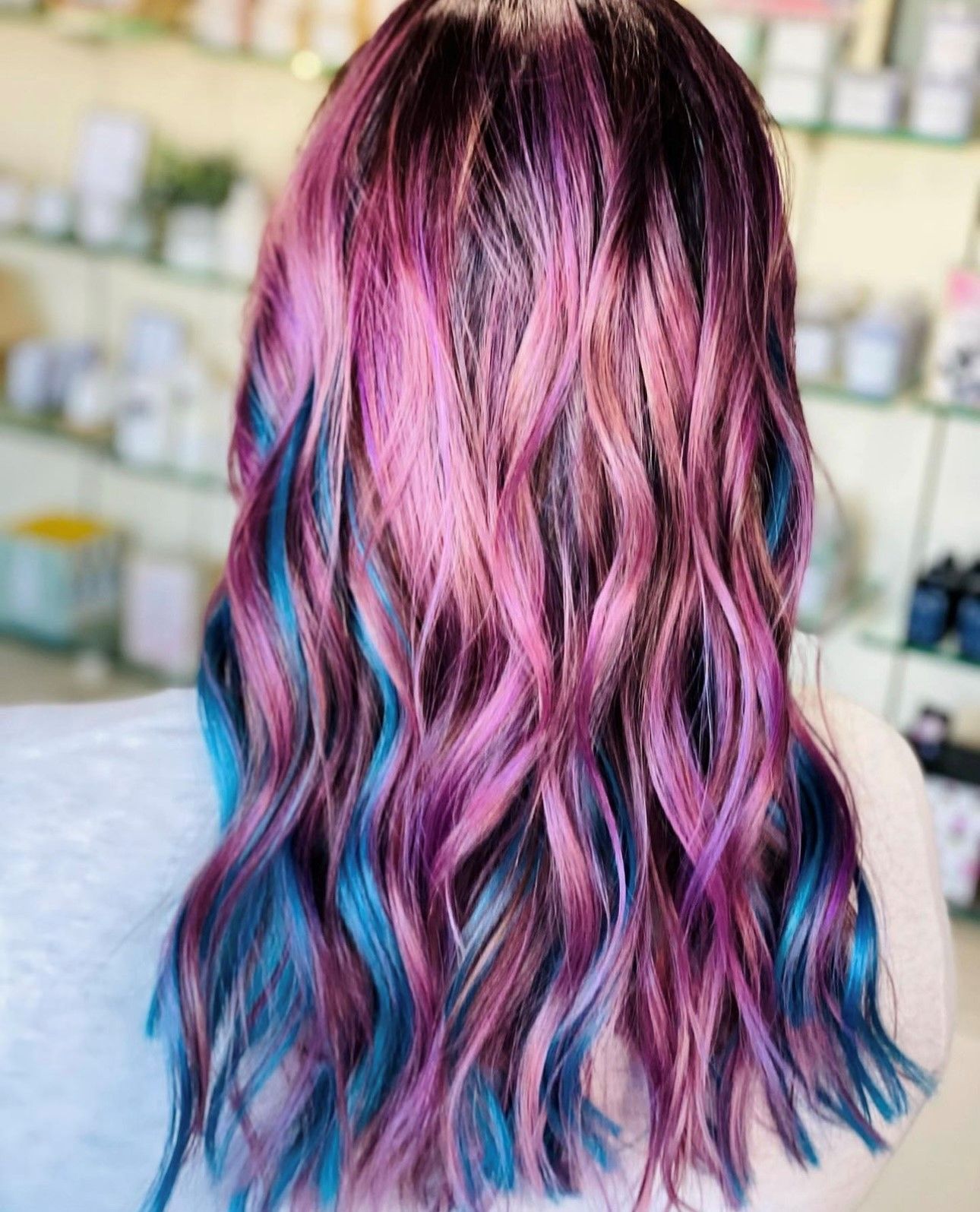 a woman with purple and blue hair is wearing a white shirt