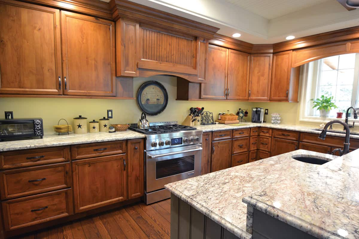 Kitchen with brown wooden cabinets, granite countertops, and a stainless steel oven.