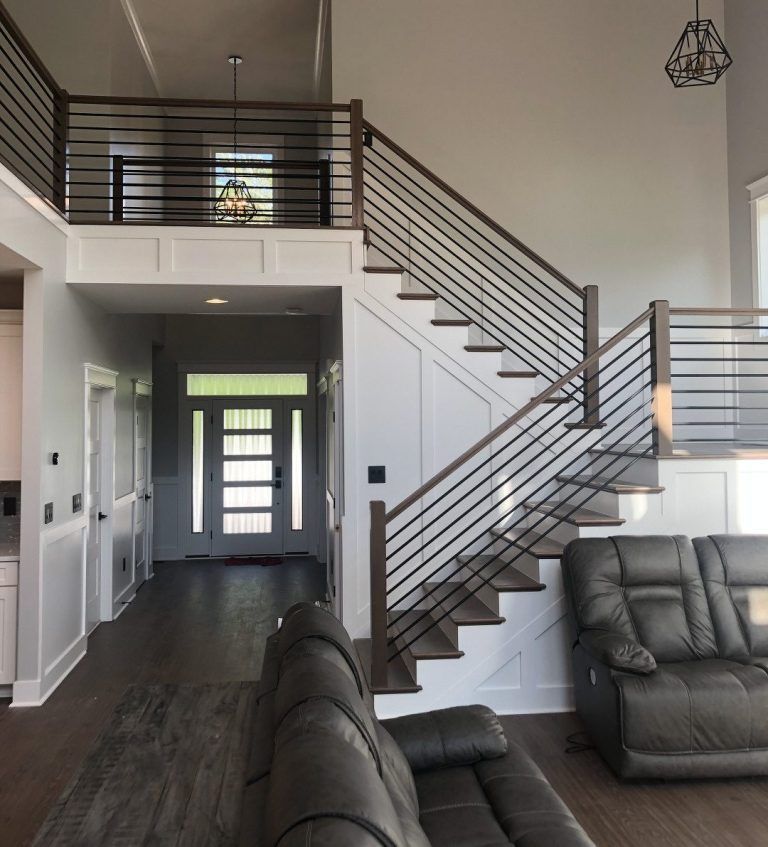 A living room with stairs leading up to the second floor