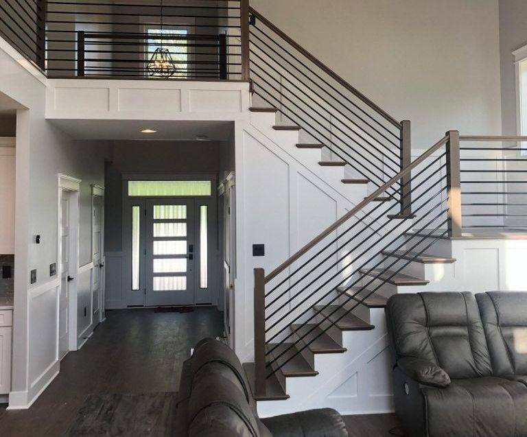 A living room with stairs leading up to the second floor