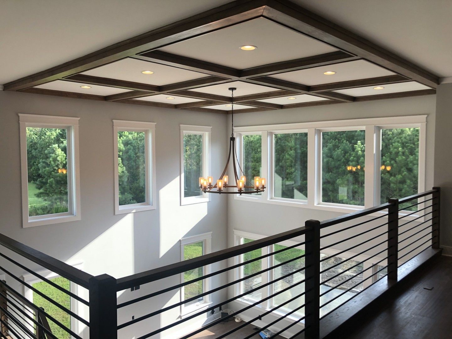 A large room with a balcony and a chandelier hanging from the ceiling.