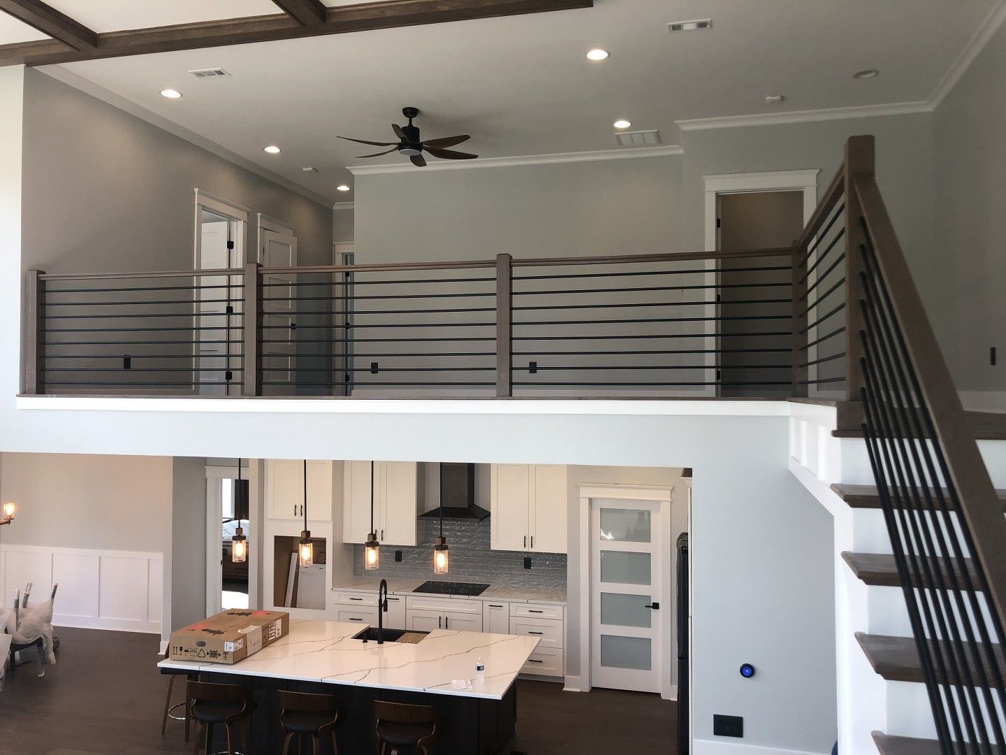 A kitchen with a balcony and stairs leading to it.