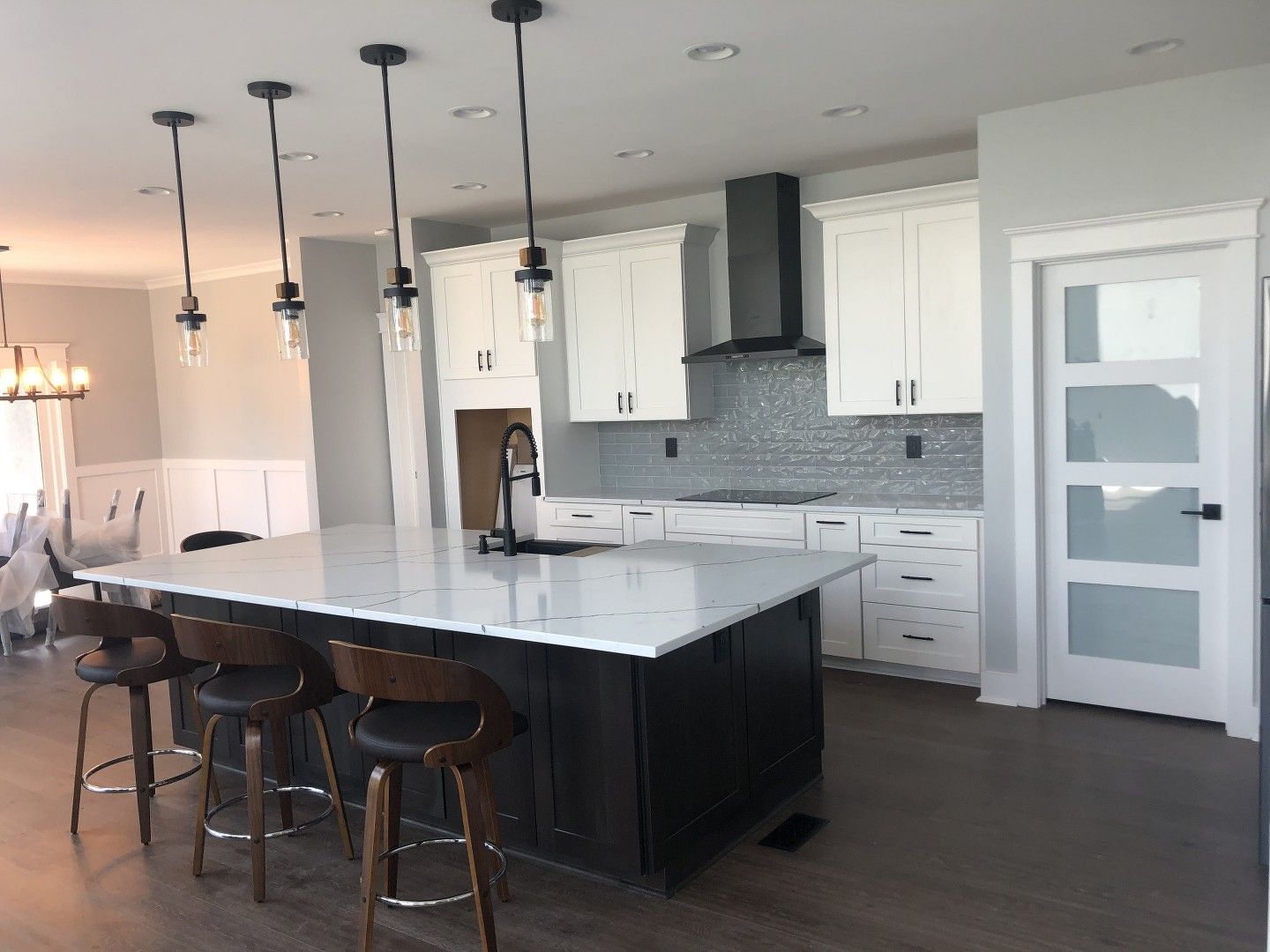 A kitchen with white cabinets and a large island.