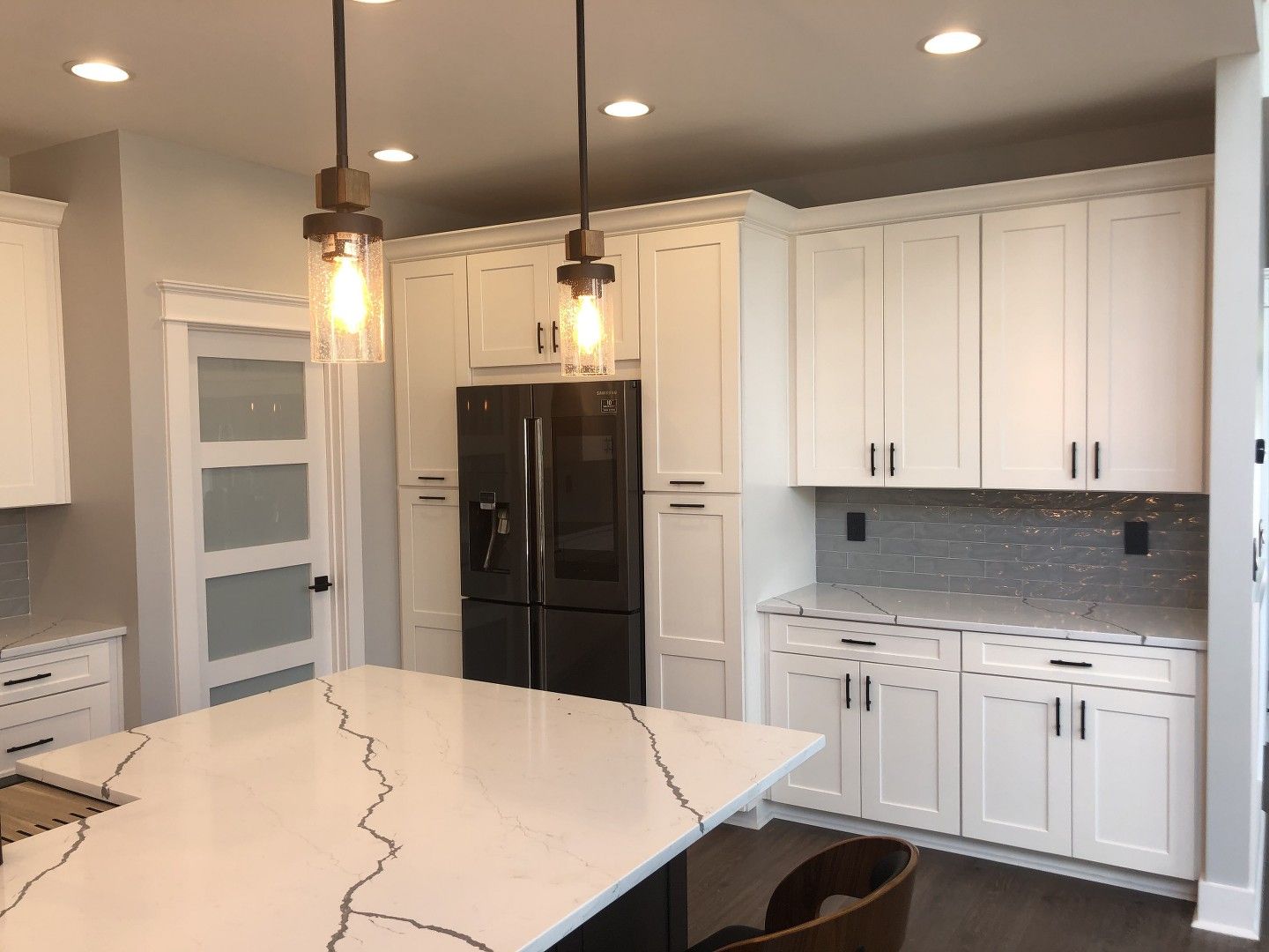 A kitchen with white cabinets and a black refrigerator