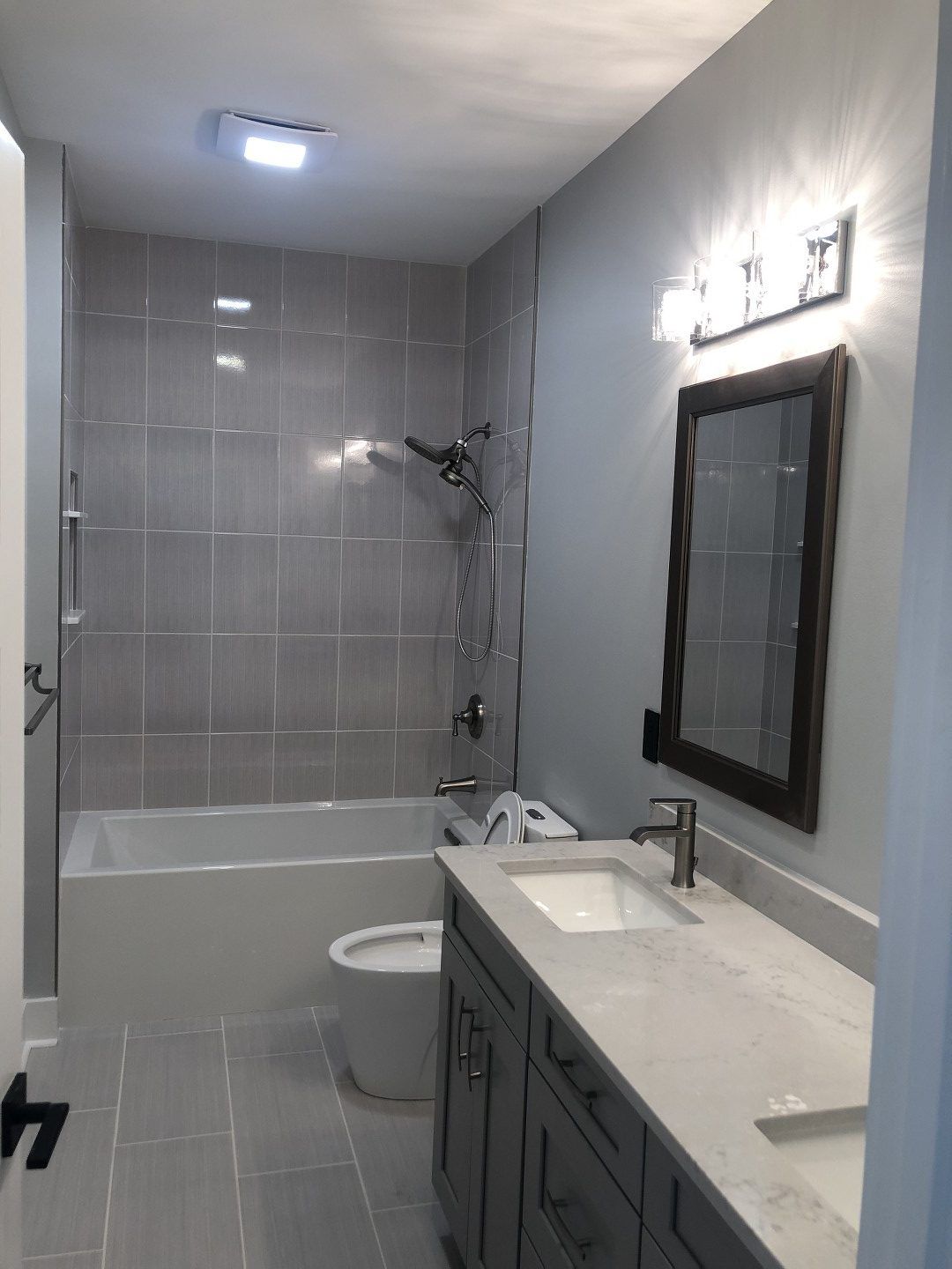 A bathroom with a sink , toilet , bathtub and mirror.