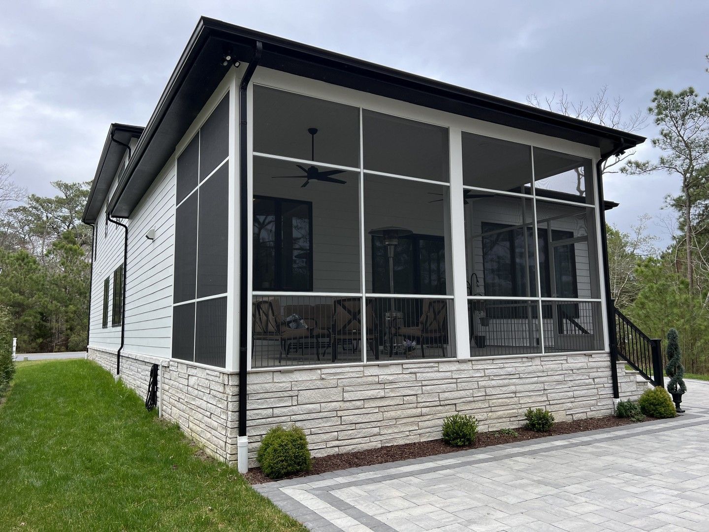 A house with a screened in porch on the side of it.