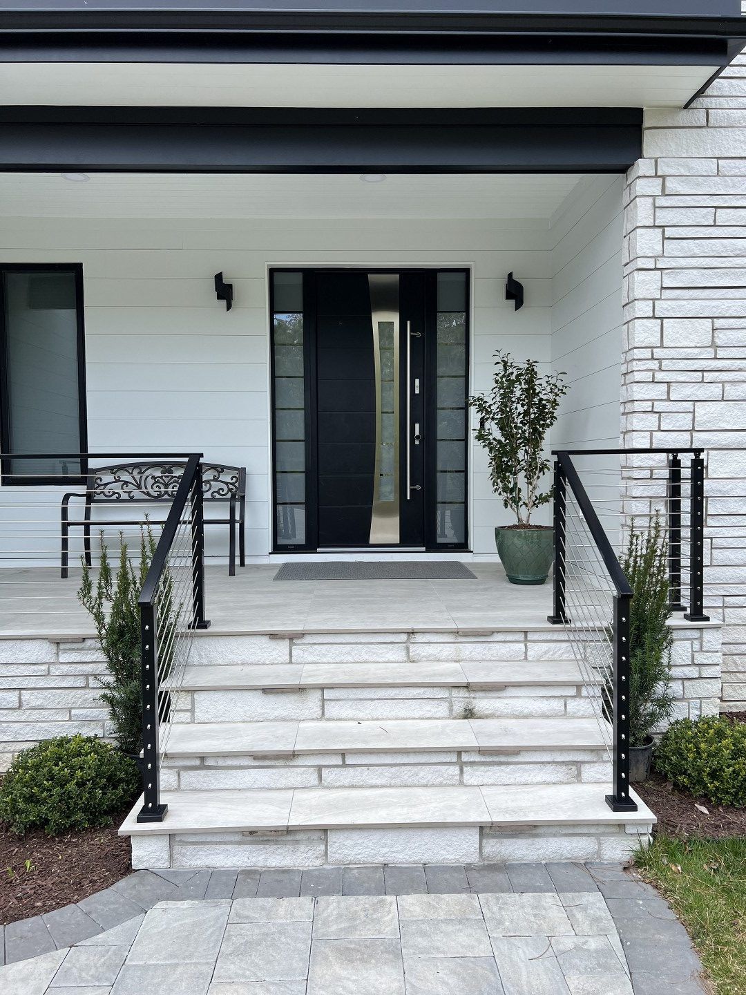 A white house with a black door and stairs