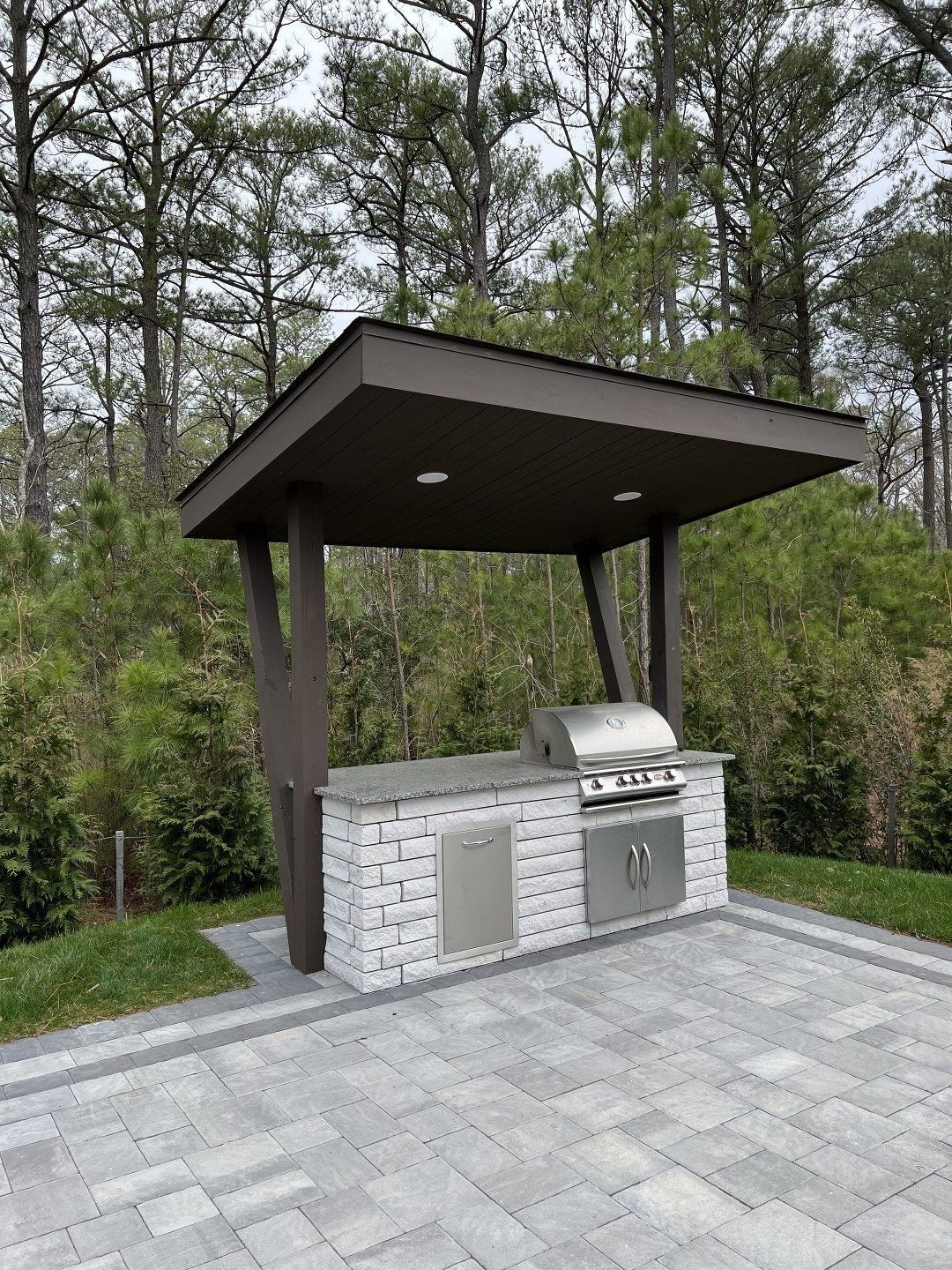 A patio with a grill and a canopy over it.