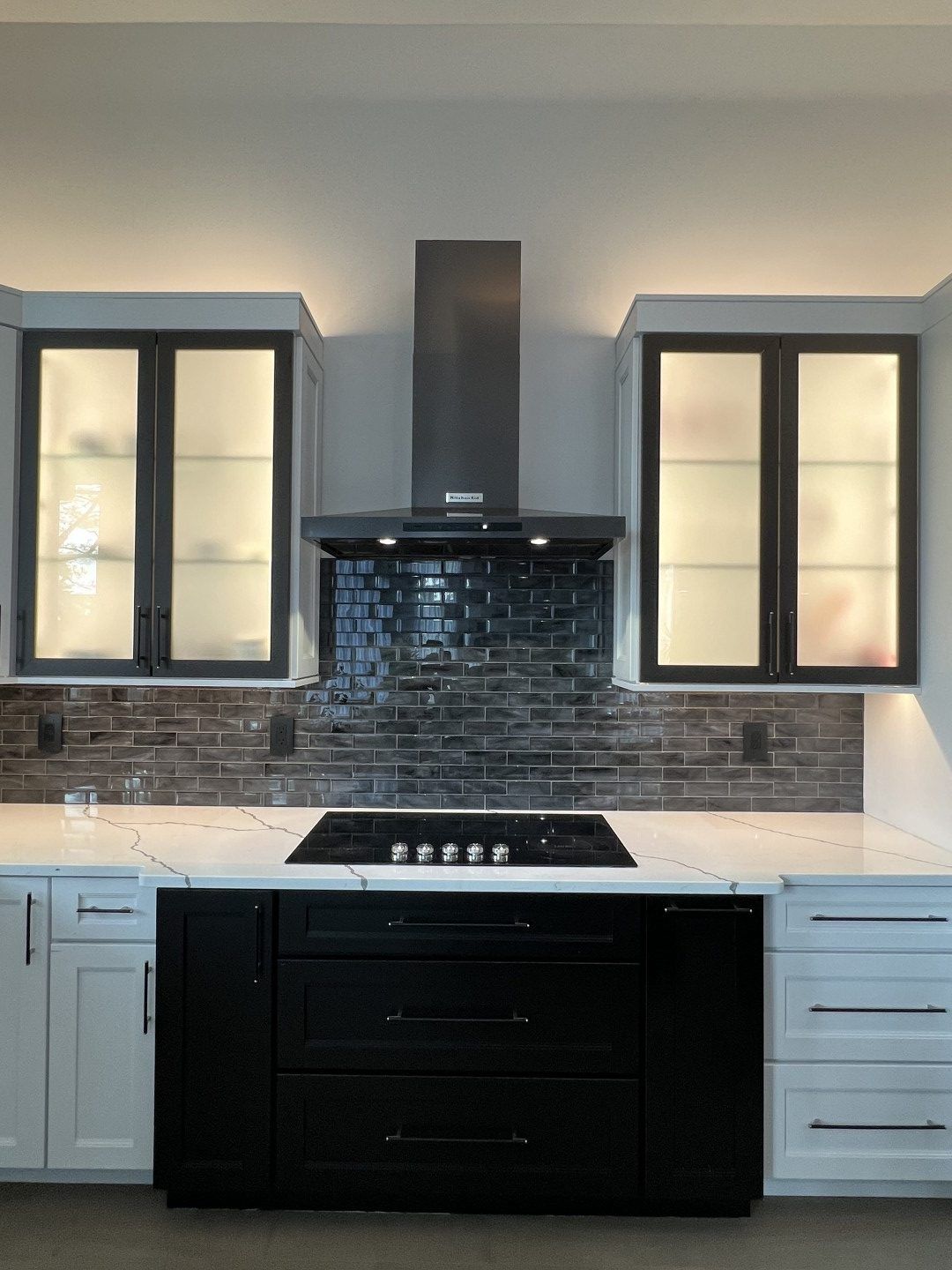 A kitchen with black cabinets and a stove top oven