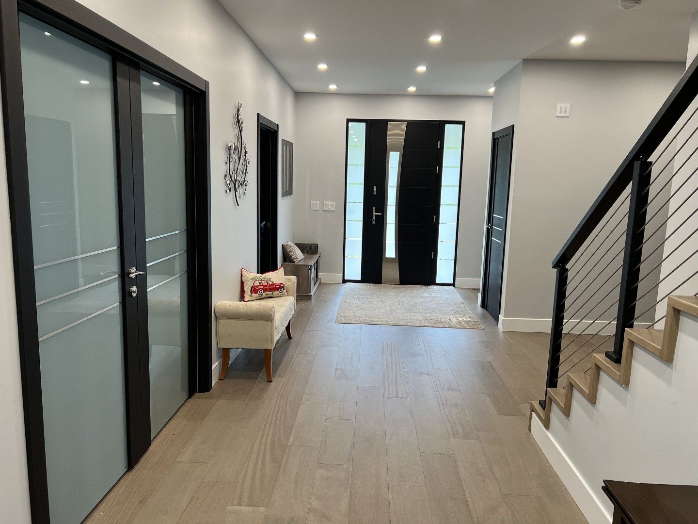 A hallway with stairs leading up to the second floor of a house.